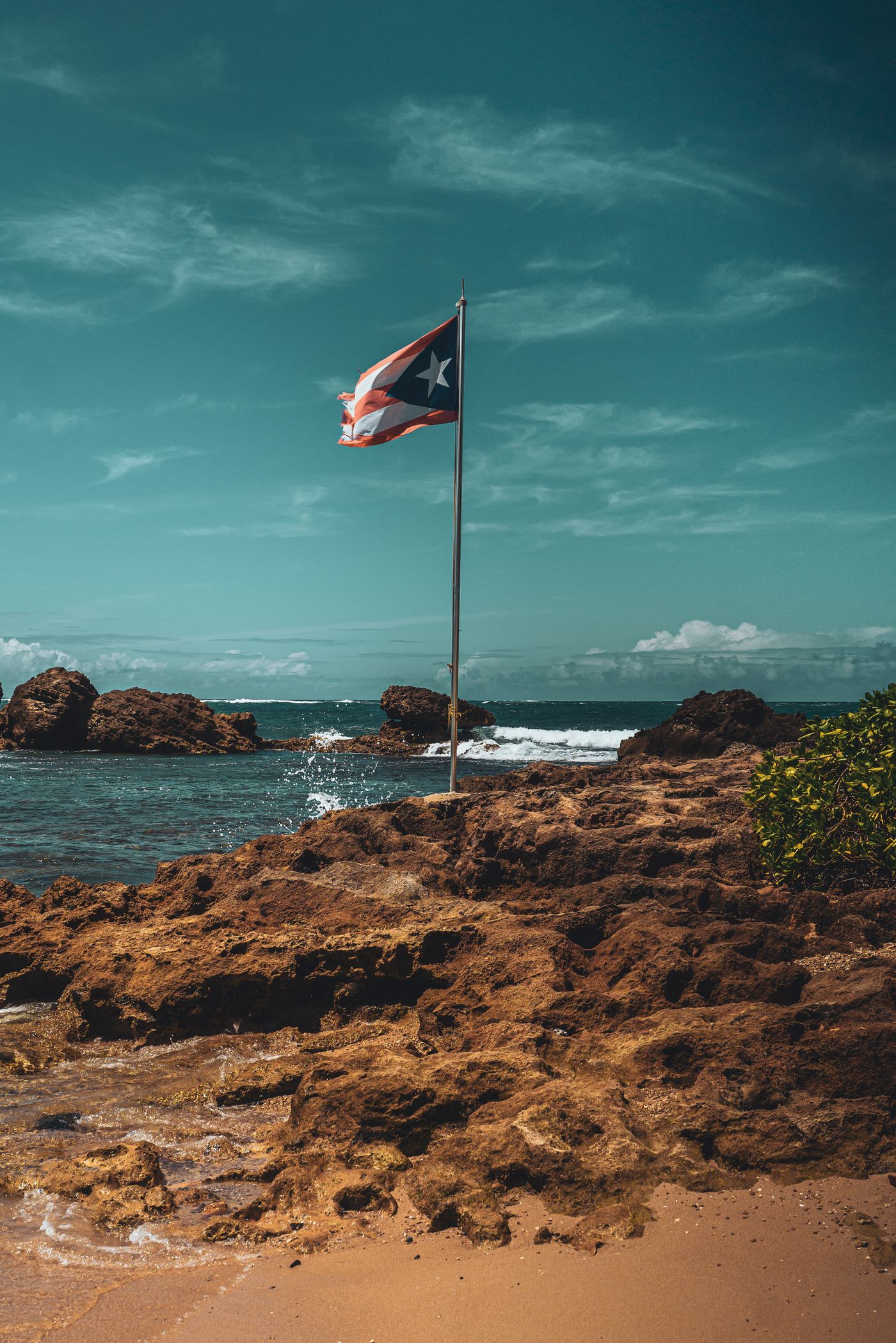 The Puerto Rican flag on the rocks at the edge of San Juan