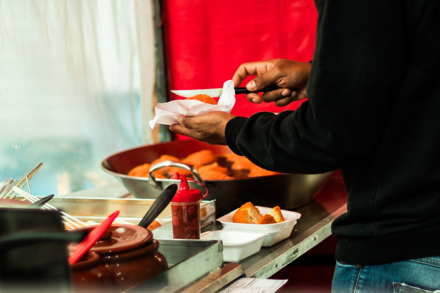 A roadside vendor frying snacks at a kiosk